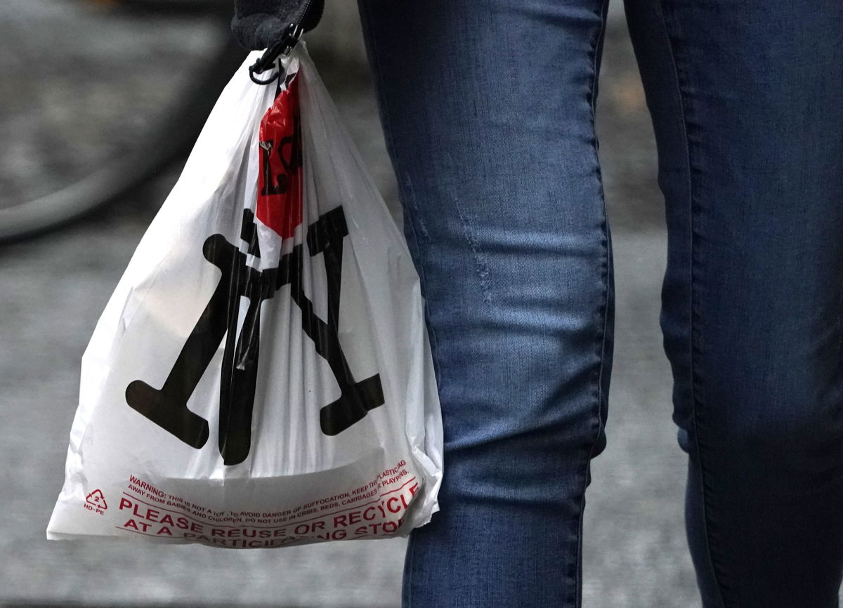 A person with their lunch in a plastic bags walks in midtown in New York on February 28, 2020, ahead of the statewide ban on plastic bags that takes effect March 1. - Consumerist mecca New York targets its throwaway culture this weekend with a ban on single-use plastic bags that has been years in the making and is still rare in America. New Yorkers like to see themselves at the forefront of efforts to save the environment but have become used to receiving groceries in free poly bags often doubled for solidity. On Sunday, that will change when New York becomes only the third US state to outlaw the non-biodegradable carriers blamed for choking rivers, littering neighborhoods and suffocating wildlife. (Photo by TIMOTHY A. CLARY / AFP) (Photo by TIMOTHY A. CLARY/AFP via Getty Images)