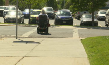 woman in wheelchair crosses street