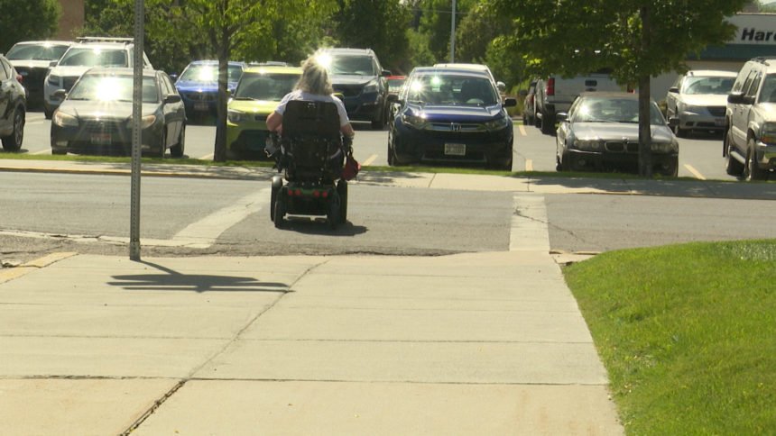 woman in wheelchair crosses street