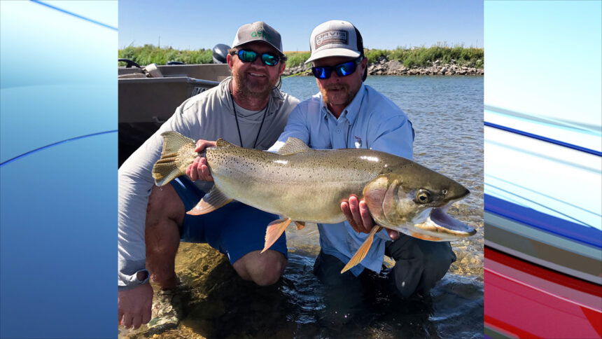 Sam Hix of Bellaire, Texas (left) with guide Josh Heilson (right) shows off a 30.5-inch Yellowstone cutthroat trout from the Snake River.