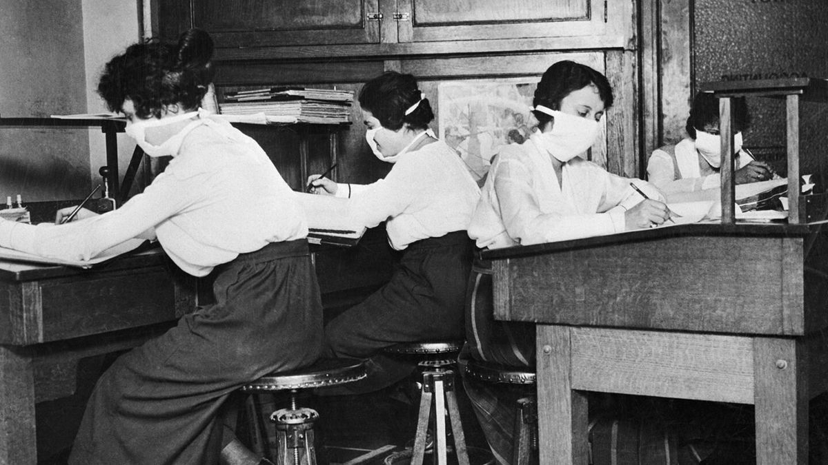 Women wear cloth surgical-style masks to protect against influenza. A worldwide influenza epidemic killed 20 million people between 1918 and 1920.
