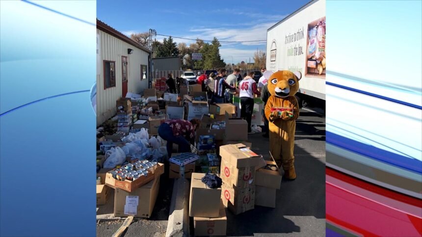Hundreds of volunteers helped load all the 7000 lbs of food to the Community Food Basket truck, including White Pine mascot, Cougar.