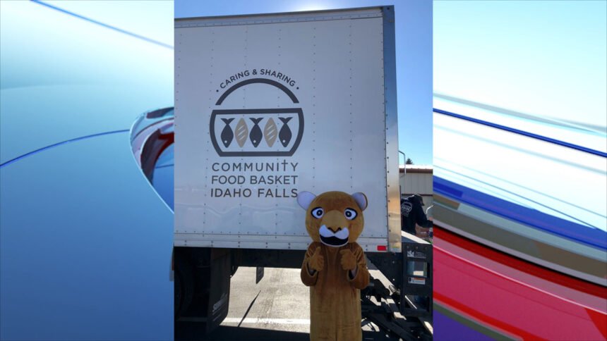 LOADING all the 7000 lbs of food to the Community Food Basket truck, including White Pine mascot, Cougar.