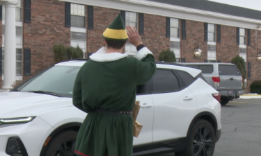 Volunteer Joel Shokes waves at family during Sunday's drive-thru event