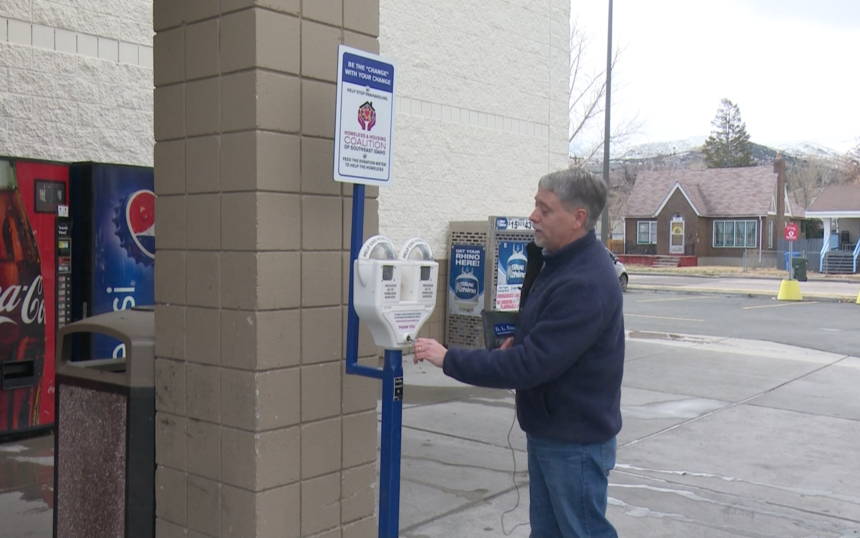 NeighborWorks Pocatello Executive Director Mark Dahlquist empties donation meter outside of Ridley's in Pocatello, ID