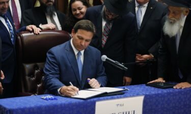 Florida Gov. Ron DeSantis' warning this week of a "Faucian distopia" offered the latest glimpse at how ambitious Republicans eyeing 2024 presidential bids are increasingly targeting public health officials as they attempt to grow their national brands in front of conservative audiences. DeSantis is shown here signing two bills at the Shul of Bal Harbour on June 14