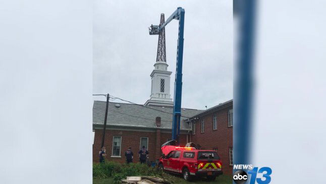 <i>Asheville Fire Department via WLOS</i><br/>Asheville fire crews are on scene for a bucket truck that had malfunctioned during maintenance on a church steeple.