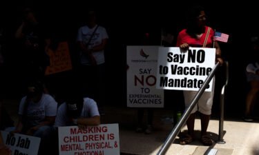 Anti-vaccine rally protesters hold signs outside of Houston Methodist Hospital in Houston
