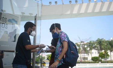 Visitors display vaccine verification at the entrance to the Museum of Tomorrow in Rio de Janeiro