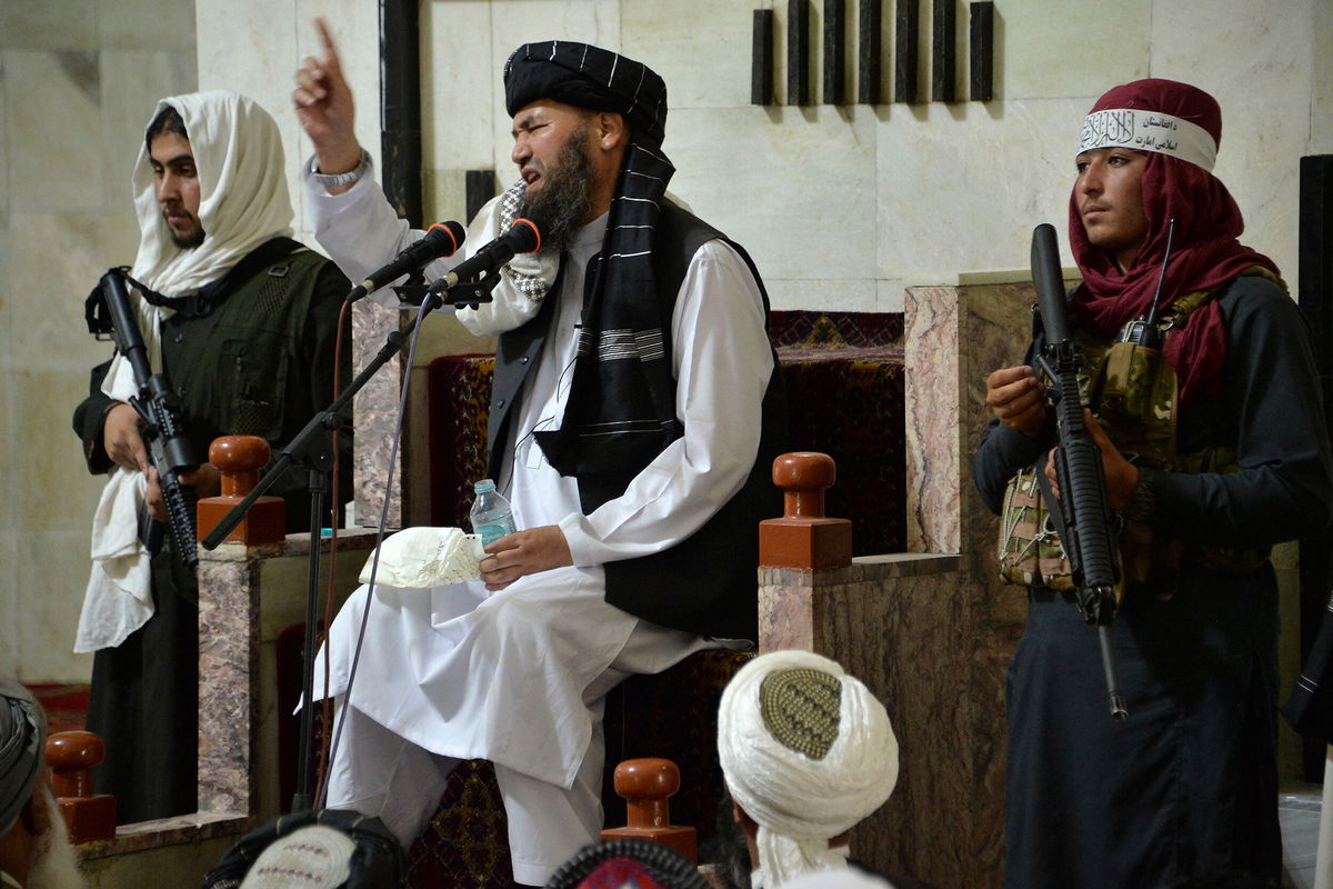 <i>Hoshang Hashimi/AFP/Getty Images</i><br/>Armed Taliban fighters stand next to a Mullah