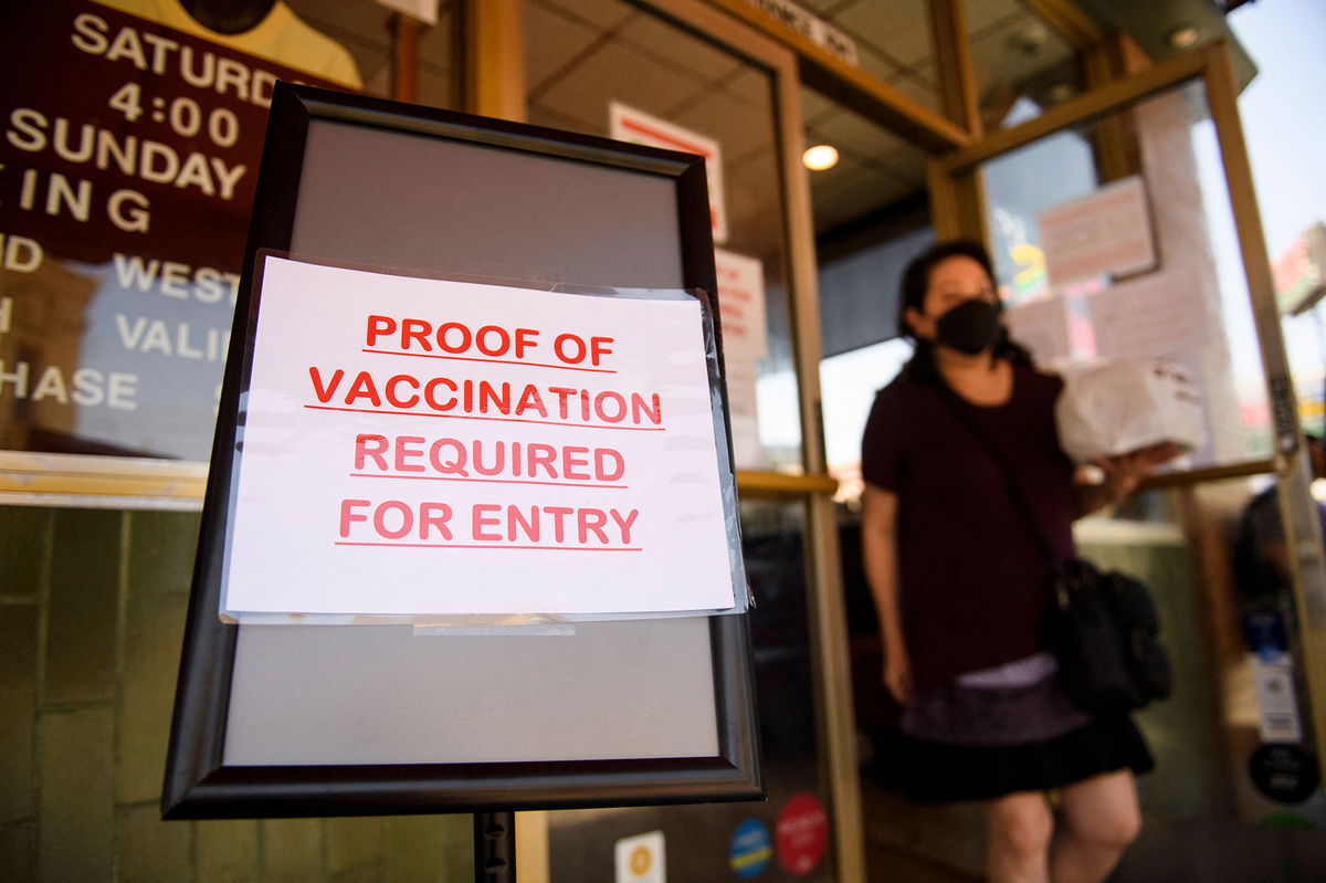 A sign stating proof of a Covid-19 vaccination is required is displayed outside of Langer's Deli in Los Angeles on August 7.