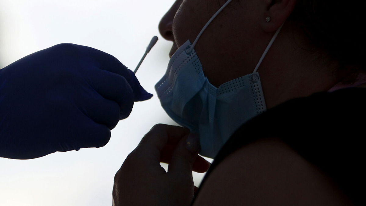 <i>Joe Raedle/Getty Images</i><br/>A person receives a COVID-19 test from EMT Christopher Linares at a Blue Med Consultants facility on September 9