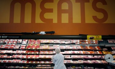 An employee restocks shelves with pork in the meat section at a Kroger Co. supermarket in Louisville
