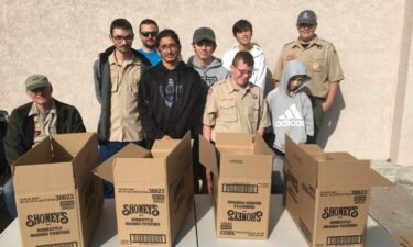 Scouts stand in front of Ridley's Market for Scouting for Food Drive