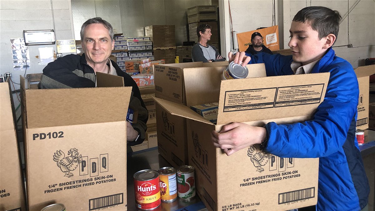 In this 2019 photo, Matt Stelzer (left), Assistant Scoutmaster for Holy Spirit Catholic Community’s Troop 315 in Pocatello, and his son, Jacob (right), sort food donations into boxes during the annual Scouting for Food drive of the local District of the Grand Teton Council of the Boy Scouts of America.