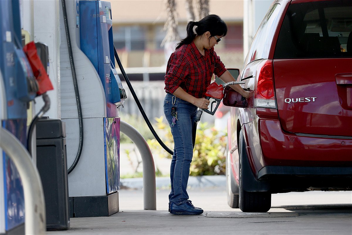 A customer pumps gas into her vehicle at a gas station on November 22, 2021 in Miami, Florida.