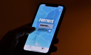 This illustration picture shows a person waiting for an update of Epic Games' Fortnite on their smartphone in Los Angeles on August 14