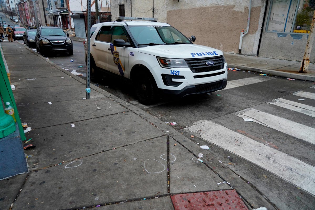 <i>Michael Perez/AP</i><br/>A Philadelphia police vehicle is seen parked next to chalk marks that identified spent bullet casings on Dec. 31.