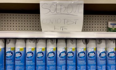 A handwritten notice is posted on an empty shelf after at-home Covid-19 test kits were sold out at a CVS store in La Habra
