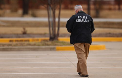 A police chaplain walks near the Congregation Beth Israel synagogue in Colleyville