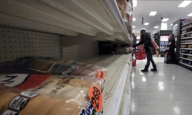A shopper walks past partially empty bread shelves at a Target store in the Queens borough of New York City