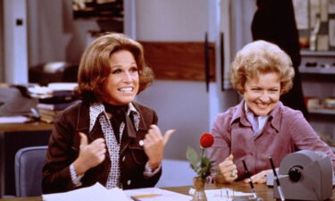 American actress Mary Tyler Moore (as Mary Richards) (left) gives a 'thumbs up' sign as she sits at her desk with Betty White (as Sue Ann Nivens) in a scene from 'The Mary Tyler Moore Show' in 1975.