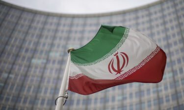 A national flag of Iran waves in front of the building of the International Atomic Energy Agency