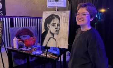 Kate Brown poses with painting at 2022 Art Battle in Pocatello