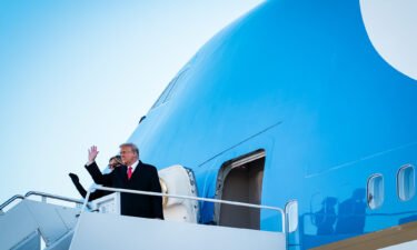 Then-President Donald Trump and first lady Melania Trump wave to supporters as they board Air Force One to head to Florida on January 20