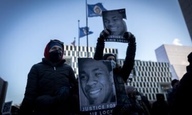 Demonstrators hold photos of Amir Locke during a rally in protest of his killing