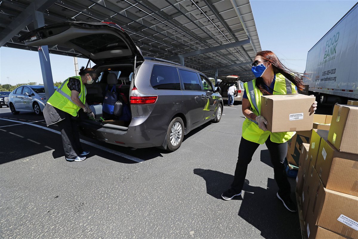 <i>John G Mabanglo/EPA-EFE/Shutterstock</i><br/>Volunteers and members of the Food Bank of Contra Costa and Solano counties help distribute food to people in need