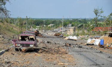 Debris and destroyed cars are seen along the street in Lysychansk