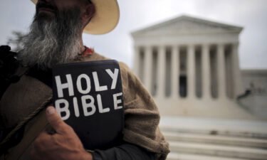 A protester holds a copy of the bible outside of the U.S. Supreme Court building in Washington June 15