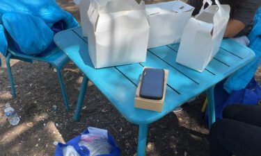 A government-issued cell phone sits on a table in a park where recently released migrants have been gathering in San Antonio