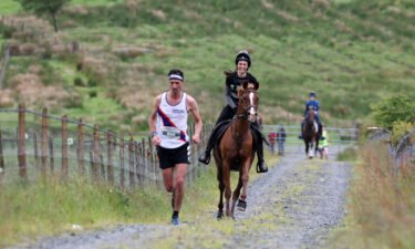 Runners compete against horses and their riders at the race which was staged after a two-year absence due to the coronavirus pandemic.
