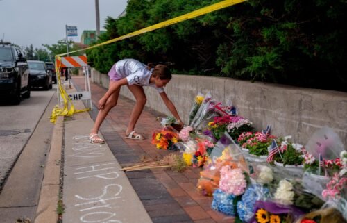 A mourner visits a memorial for the victims of a mass shooting at a Fourth of July parade