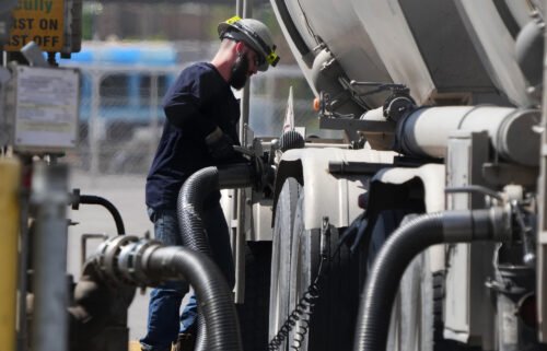 A driver unloads raw crude oil from his tanker to process into gas at Marathon Refinery on May 24