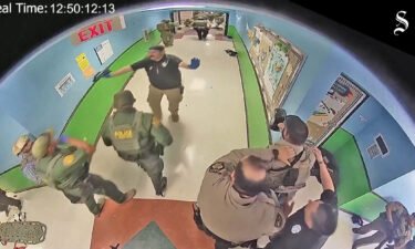 Law enforcement officers are told to stay back as shots are heard down the hall during a police entry into the Robb Elementary school classroom in which Salvador Ramos was located in Uvalde