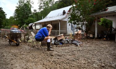 Teresa Reynolds sits exhausted as members of her community clean the debris from their flood ravaged homes at Ogden Hollar in Hindman