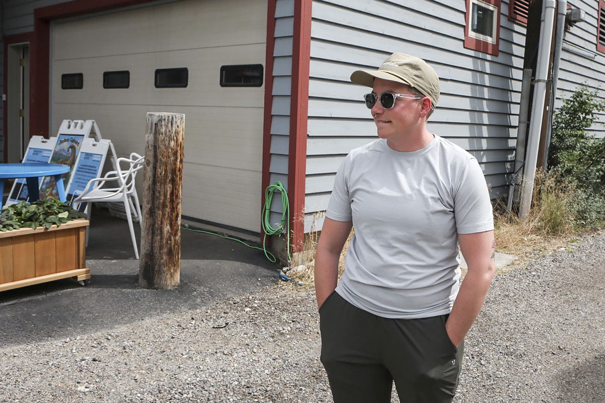 Ash Hermanowski, the food access and operations manager of the Jackson Cupboard, poses for a portrait on Wednesday, Aug. 24, 2022, in Jackson Hole, Wyo. Hermanowksi hands out meals from a commercial garage downtown after the nonprofit was forced out of a previous location by a malfunctioning sprinkler. As the Federal Reserve's annual Jackson Hole economic symposium gets under way Thursday, some of the very problem federal officials are grappling with – high inflation, soaring home prices, and stark financial inequality – are all too visible in the idyllic mountain setting where the economic conference takes place.