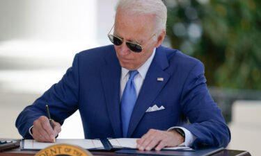 President Joe Biden signs two bills aimed at combating fraud in the Covid-19 small business relief programs on August 5 at the White House in Washington.