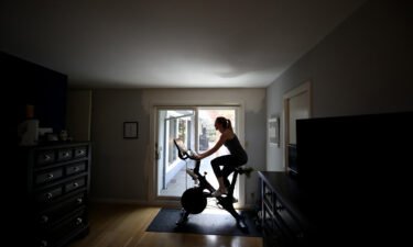 Jen Van Santvoord rides her Peloton exercise bike at her home in San Anselmo