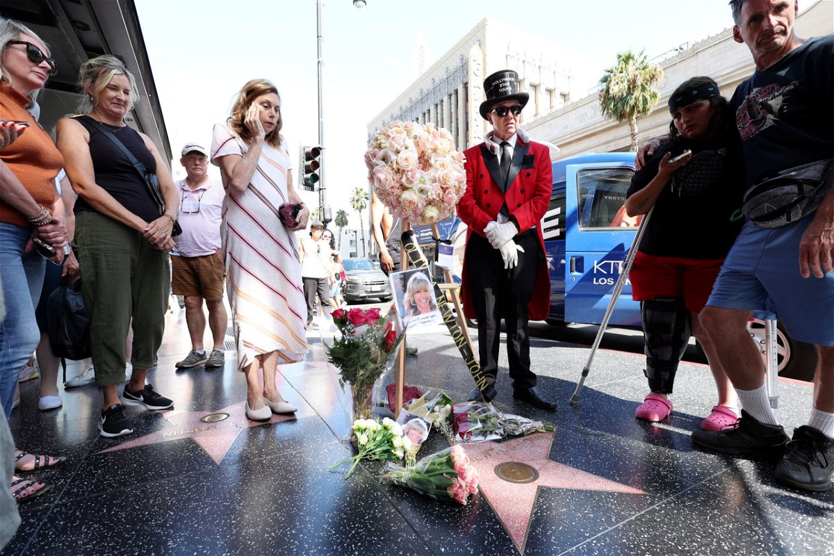 <i>Mario Anzuoni/Reuters</i><br/>People lay flowers by the star of late actor Olivia Newton-John on the Hollywood Walk of Fame in Los Angeles