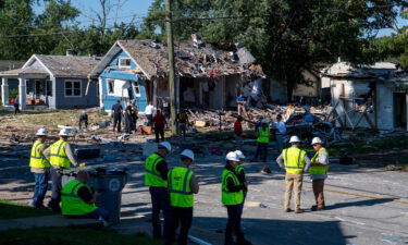 Emergency personnel search the debris left behind by an August 11