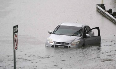 A car sits in flood waters covering a closed highway in Dallas on August 22. More than 1