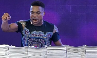 Nigerian preacher Jerry Eze prays over stacks of requests received from his followers.