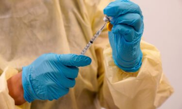 Health officials are banking on vaccinations to contain monkeypox and polio before those become standing threats in the United States. A physician assistant prepares a syringe with the monkeypox vaccine in New York on August 19.