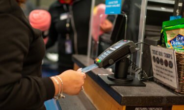 An air traveler uses a credit card to pay for items on January 28 at a retail shop in John F. Kennedy International Airport in New York City. More Americans are relying on credit cards.