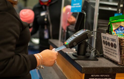 An air traveler uses a credit card to pay for items on January 28 at a retail shop in John F. Kennedy International Airport in New York City. More Americans are relying on credit cards.