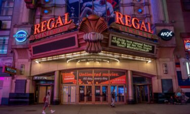 Pedestrians pass in front of a Regal Cinemas movie theater in New York